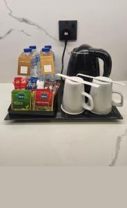 a tray with two coffee mugs and a tea kettle at Abu Dhabi Budget Smart Stay in Abu Dhabi +20 photos