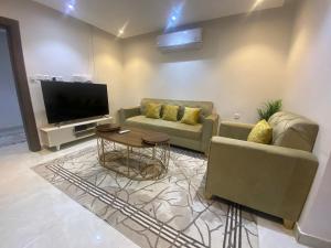 a living room with two couches and a tv at شقة راقية 3 غرف نوم وصالة ومطبخ وحمامين حي باقدو a1 in Medina