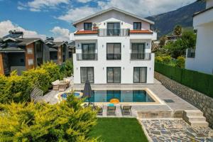 オルデニズにあるATLANTİS- 4 Bedroom Holiday Villa in Hisaronuの庭にスイミングプールがある白い家
