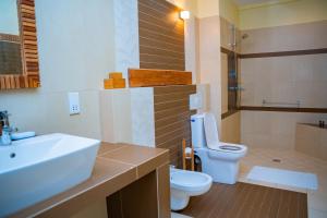 a bathroom with a white sink and a toilet at Villa Vanilla in Port Glaud