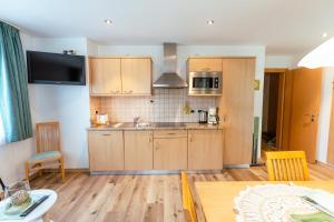 a kitchen with wooden cabinets and a table in a room at Haus Angelika in Nova Levante