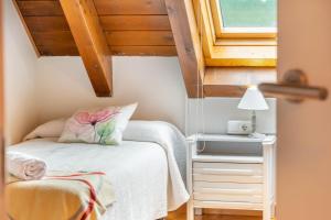 een kleine slaapkamer met een bed en een raam bij Casa Ferran, amplias habitaciones y apartamentos de montaña in Valcarlos