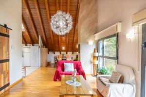 a living room with a table and a chandelier at Casa Ferran, amplias habitaciones y apartamentos de montaña in Valcarlos