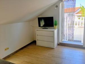 a living room with a television on a dresser with a window at Apartment Marina in Brzac