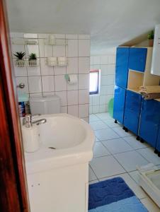 a bathroom with a white sink and blue cabinets at Apartment Marina in Brzac