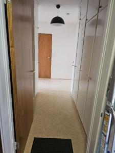 a hallway with lockers and a room with a door at Katrineholm Longstay - Fully equipped 2-room apartment in Katrineholm
