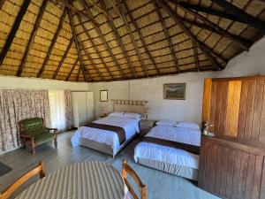 a bedroom with two beds and a wooden ceiling at Pavlovna Comfy 4 Cottage in Himeville