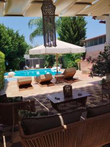 a patio with chairs and an umbrella and a pool at Luxury Villas Chrysa Private Pool & Spa in Nafplio +207 photos