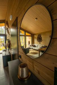 a circular mirror on the wall of a room at Villa Golden Hill Ylläs, Luxury holiday cabin in Lapland in Äkäslompolo