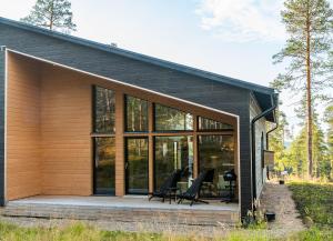 a house with glass windows and a wooden deck at Villa Golden Hill Ylläs, Luxury holiday cabin in Lapland in Äkäslompolo