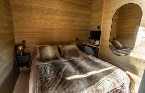 a bedroom with a bed in a wooden room at Villa Golden Hill Ylläs, Luxury holiday cabin in Lapland in Äkäslompolo
