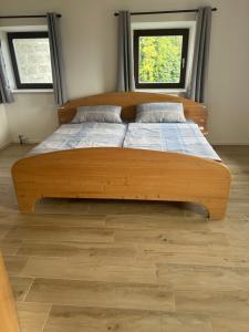 a large bed in a room with two windows at Traumpanorama zwischen Chiemsee und Salzburg - 74 qm - mit E-Ladesäule in Surberg