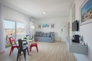 a living room with a couch and a table and chairs at Kitieos Apartments in Larnaca