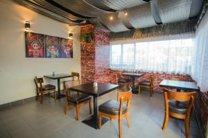 a restaurant with tables and chairs and a brick wall at Abbots Hamilton – Hotel and Conference Centre in Hamilton