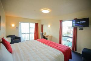 a hotel room with a bed and a large window at Abbots Hamilton – Hotel and Conference Centre in Hamilton