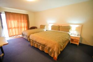 a hotel room with two beds and a window at Abbots Hamilton – Hotel and Conference Centre in Hamilton
