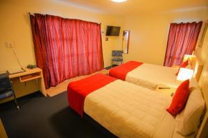 a hotel room with two beds and a window at Abbots Hamilton – Hotel and Conference Centre in Hamilton
