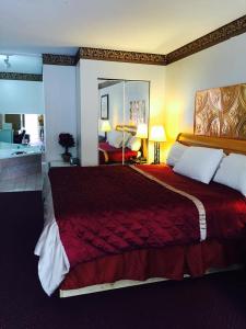 a bedroom with a large bed with a red blanket at Super Inn Downtown in Bardstown