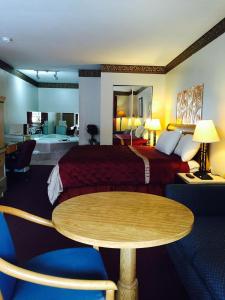 a hotel room with a bed and a table at Super Inn Downtown in Bardstown