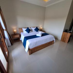 a bedroom with a large bed with blue pillows at DJumah House in Ubud +15 photos