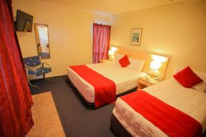 a hotel room with two beds and a chair at Abbots Hamilton – Hotel and Conference Centre in Hamilton +37 photos