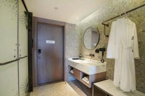 a bathroom with a sink and a mirror at Baoli International Hotel - Yangjiang Baili Plaza in Yangjiang