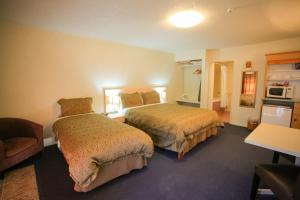 a hotel room with two beds and a chair at Abbots Hamilton – Hotel and Conference Centre in Hamilton
