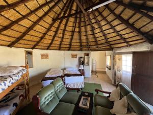 a large room with two beds and a couch at Pavlovna Bunk with the kids Cottage in Himeville