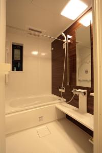京都市にあるKokon Higashiyamaのバスタブと洗面台のあるバスルーム