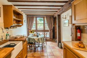 a kitchen with a table and a dining room at Poplar Cottage - Historic Barn in Dumbleton in Dumbleton