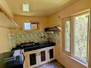 a small kitchen with a sink and a window at Reenush Homestay in Haripūr