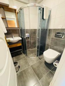 a bathroom with a shower and a toilet and a sink at Sarıgerme Apart otel in Ortaca