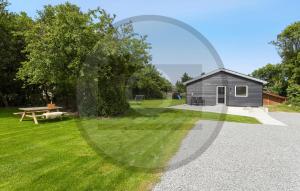 a small shed and a picnic table in a yard at Gorgeous Home In Spøttrup With Sauna in Vester Lem +2 photos