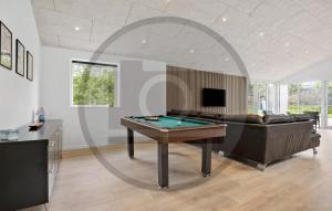 a living room with a pool table and a couch at Gorgeous Home In Spøttrup With Sauna in Vester Lem +4 photos