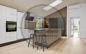 a kitchen with a counter and stools in it at Gorgeous Home In Spøttrup With Sauna in Vester Lem