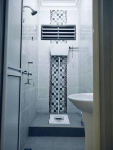a white bathroom with a sink and a shower at Adyan Homestay Terengganu in Bukit Payong