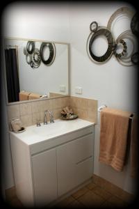 ein Badezimmer mit Waschbecken, Spiegel und Handtüchern in der Unterkunft York's Boutique Motel in York