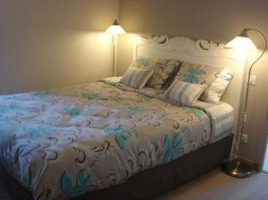 a bedroom with a large bed with blue flowers on it at Chambres d'Hôtes La Villa des Hortensias in Berck-sur-Mer