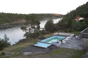 una piscina junto a un cuerpo de agua en Sjøverstø Holiday, en Tvedestrand