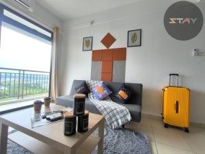 a living room with a couch and a table and a yellow suitcase at The Garden 2BR 4Pax Cozy Stylish Netflix BySTAY in Skudai