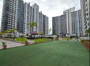 a green lawn in the middle of two tall buildings at The Garden 2BR 4Pax Cozy Stylish Netflix BySTAY in Skudai