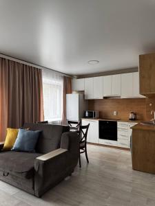 a living room with a couch and a kitchen at Seven City Apartments in Semey
