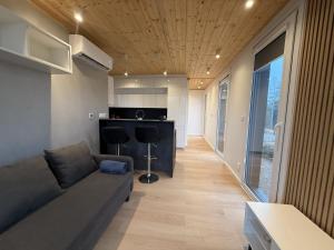 a living room with a couch and a kitchen at Holiday home in the middle of nature in Knared in Eslared +12 photos