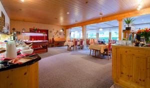 a kitchen and dining room with tables and chairs at Hotel am Kurpark in Todtmoos