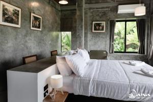 a bedroom with a large bed and a window at Nana Villa in Ko Yao Noi