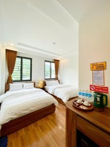 a room with three beds and a sign on the wall at Hotel Thanh Phương 1 in Mèo Vạc