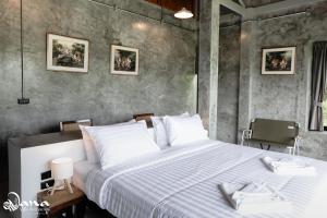 a bedroom with a large bed with white pillows at Nana Villa in Ko Yao Noi