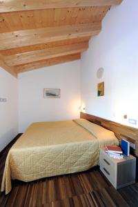 1 dormitorio con cama y techo de madera en Residence Hotel Candriai Alla Posta, en Candriai