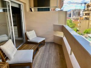 ein Balkon mit einer Bank und einem Stuhl auf einem Gebäude in der Unterkunft Esperanza Grand Apartments - Marbella Centro in Marbella