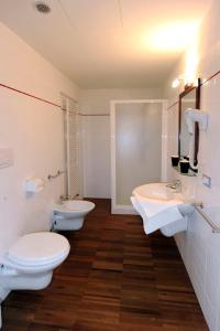 a bathroom with two sinks and two toilets at Residence Hotel Candriai Alla Posta in Candriai